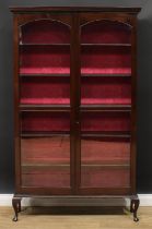An early 20th century display cabinet or bookcase, moulded cornice above a pair of glazed doors
