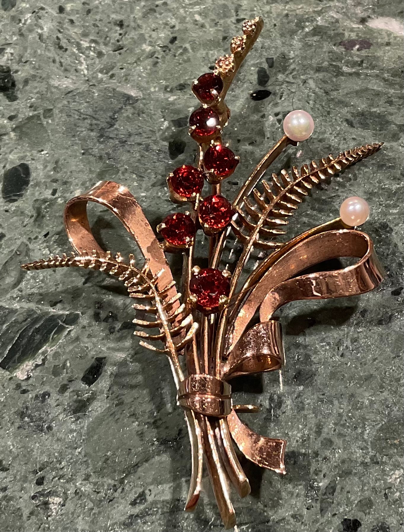 A 9ct gold garnet and seed pearl brooch, cast as a spray of ribbon tied ferns and budding stems, the - Image 2 of 4