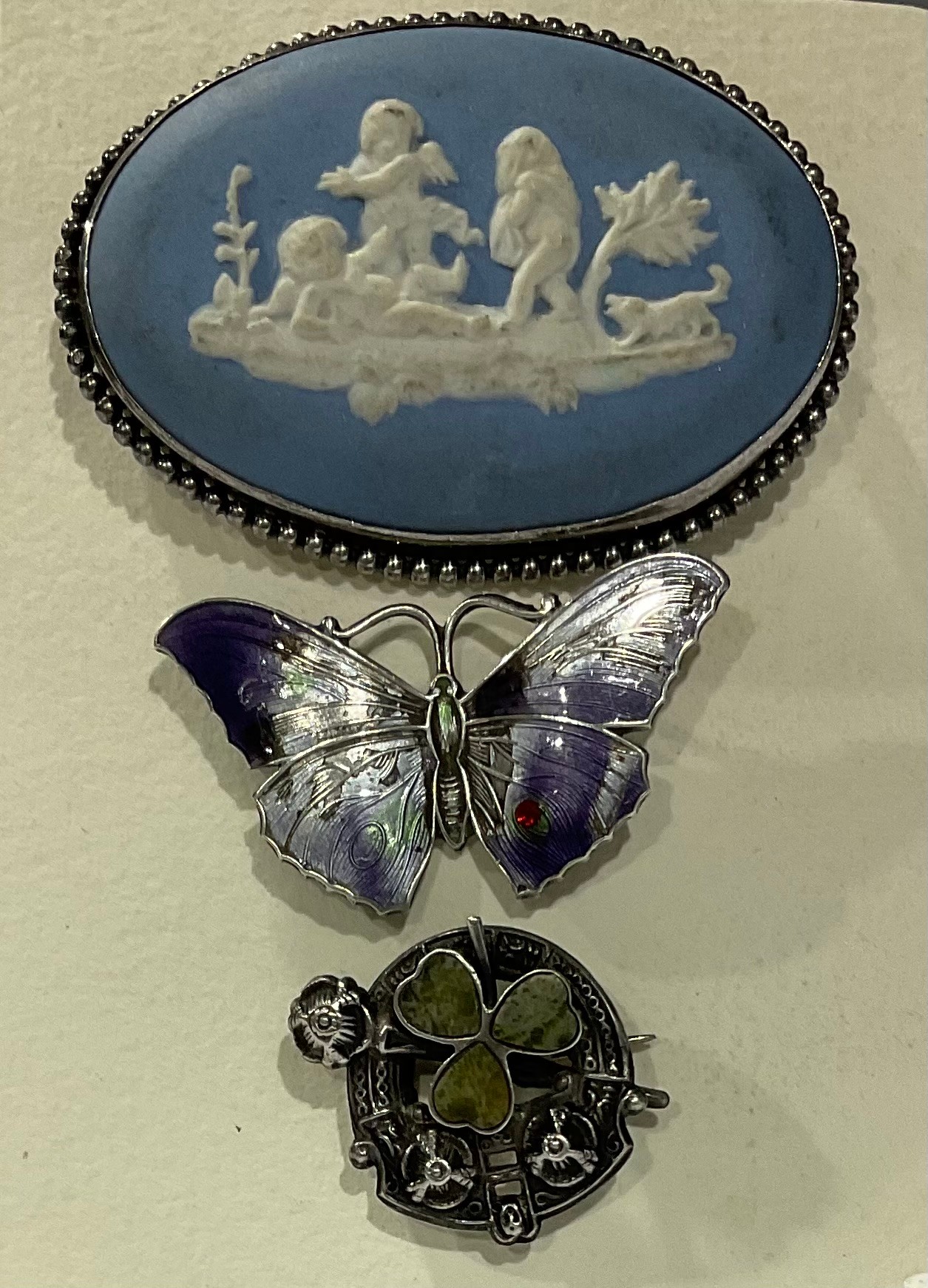 A hallmarked silver and enamel butterfly brooch; a Wedgwood brooch; a Shamrock silver brooch