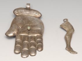 A South American silver coloured metal milagro votive, as a hand, the palm collett set with a