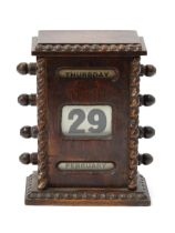 An early 20th century oak perpetual desk calendar, glazed apertures for day, date and month, 16cm