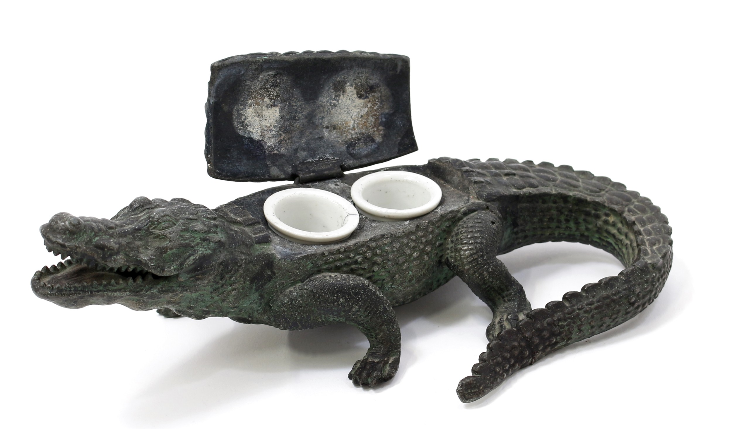 An early 20th century cold painted spelter novelty inkwell, cast as a alligator, hinged cover,