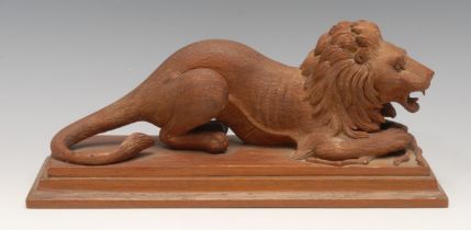 An early 20th century carving, of a lion and his kill, rectangular base, 29cm long