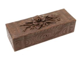 A Black Forest rectangular novelty box, hinged cover crested by a spray of flowers, carved with faux