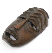 Tribal Art - an African mask, eliptical features, stepped geometric ridges to forehead, 32.5cm long,