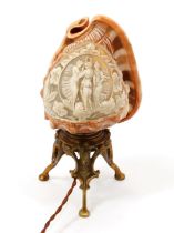 An early 20th century cameo conch shell table lamp, carved with The Three Graces, cast base, 23cm