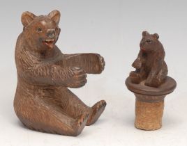 A Black Forest carving, of a bear, 9.5cm high, c.1900; a bottle stopper (2)