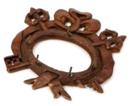 A Black Forest wall-hanging key hook, carved with triumphal regalia, 18cm wide, c.1900