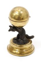 A late 19th century dark patinated bronze and polished brass novelty inkwell, the globular