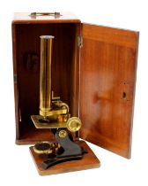 An early 20th century black-painted and lacquered brass monocular microscope, rack and pinion