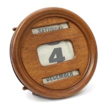 An early 20th century oak wall mounted perpetual calendar, glazed apertures for day, date and month,