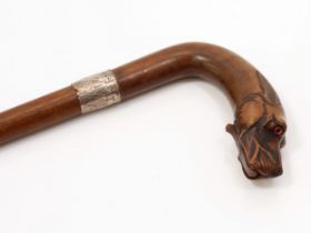 An early 20th century novelty walking stick or cane, the curved handle carved as the head of a