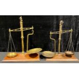 A set of late 19th/early 20th century brass balance scales, rectangular mahogany base, 47cm high;