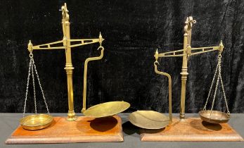 A set of late 19th/early 20th century brass balance scales, rectangular mahogany base, 47cm high;