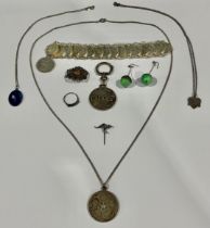 An enamel pendant; a silver pendant; a Mexican coin bracelet; etc