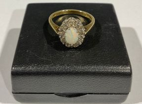 An 18ct gold opal and diamond flowerhead cluster ring, size M, the central polished oval opal