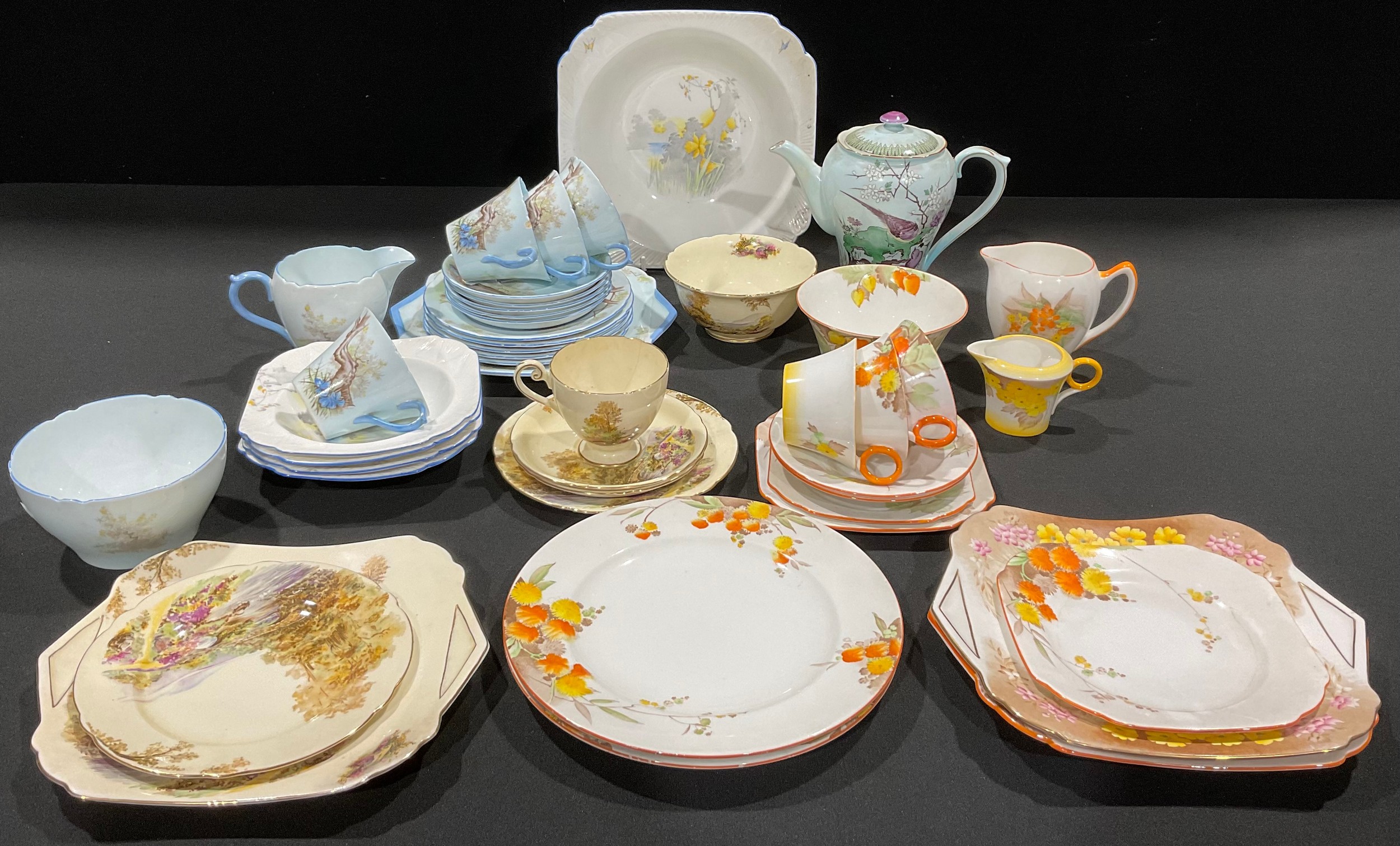 A Shelley Art Deco part tea service, decorated with tree and flowers on pale blue ground, comprising