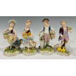 A set of four Naples porcelain figures, as boy and girl farmhands hand feeding livestock, painted in