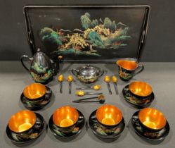 A mid century Japanese style lacquer and gilt tea service for six, depicting a river scene with