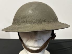 WW1 US M1917 Steel Helmet. Three holes have been drilled to each side of the rim to allow fitment of