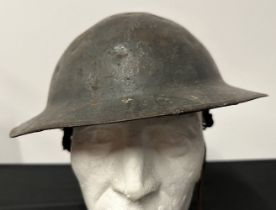 WW1 British Steel Helmet complete with liner and remains of the original leather chinstrap. Dark