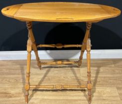 An oval oak serving tray on stand, each of the four folding leaves with pierced handles, folding x-