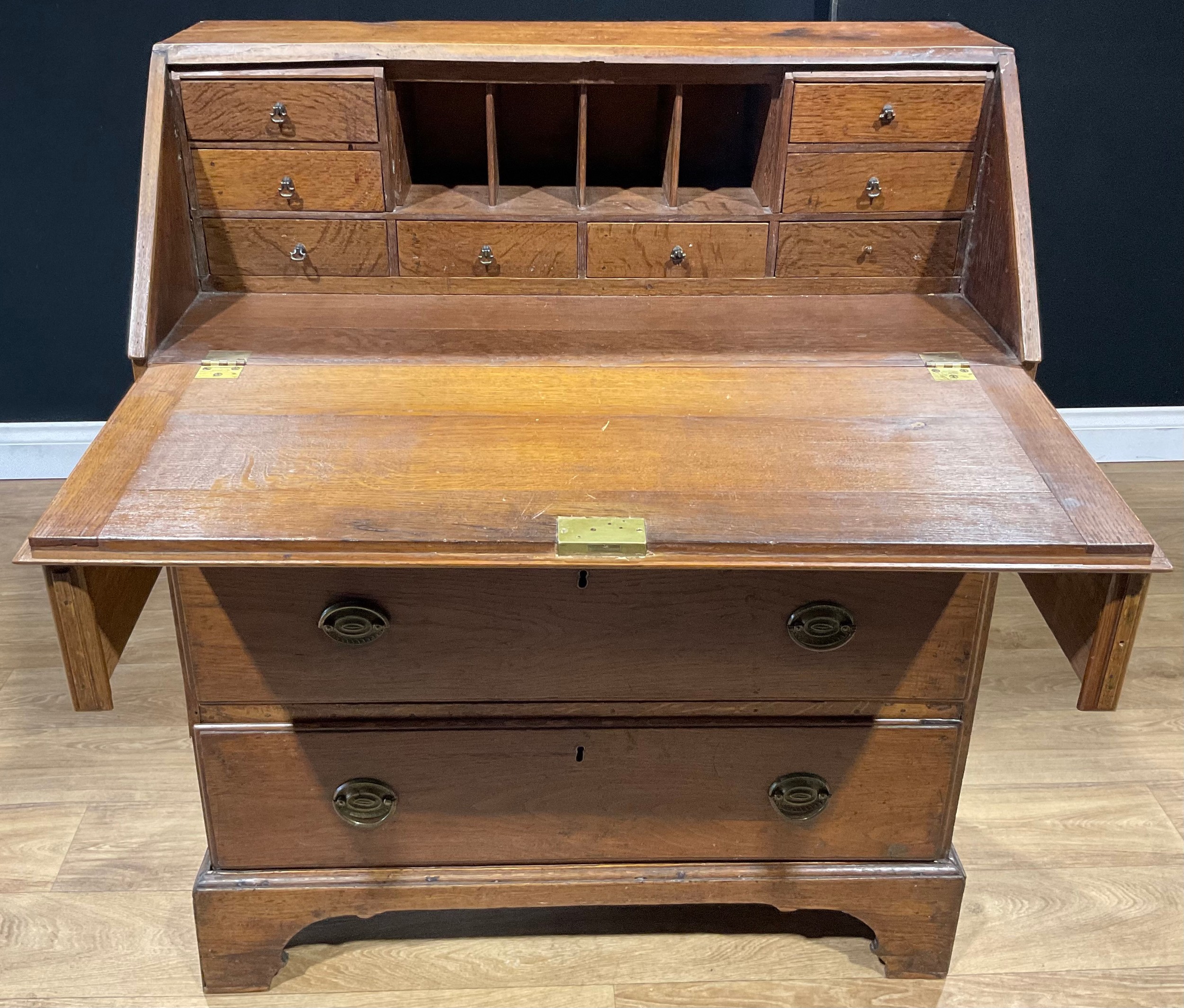 A George III oak bureau, fall front enclosing small drawers and pigeonholes, above three long - Image 2 of 3