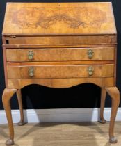 An early 20th century Queen Anne style walnut bureau, fall front enclosing a fitted interior above