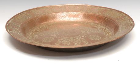 A Renaissance Revival copper rosewater dish, profusely chased and centred by an armorial, 46.5cm