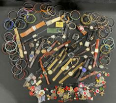 A collection of assorted watches; various badges; beadwork bracelets