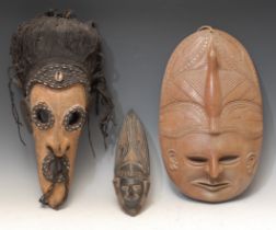 Tribal Art and the Eclectic Interior - a mask, the bold features outlined with cowrie shells,