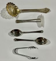 A Victorian silver sifting spoon, London 1864; a pair of silver sugar bows, Birmingham 1928; a