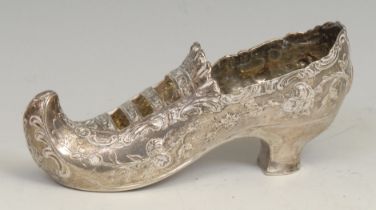 An early 20th century Continental silver novelty model, of a shoe, chased with flowers, 11.5cm long,