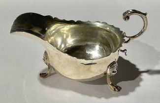 An Edward VII silver sauce boat, acanthus-capped flying scroll handle, lion paw feet with lion masks