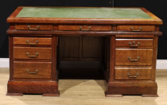 An oak twin pedestal desk, rectangular top with inset writing surface above three frieze drawers,