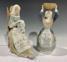 A Lladro porcelain figure, The Embroider, 28.5cm high; another, Shepherdess in Traditional Dress,