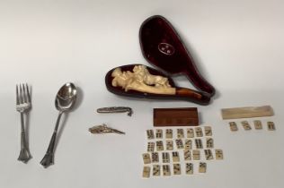 A Meerschaum pipe, the bowl carved with a lion, cased; a set of miniature bone dominoes, mother-of-