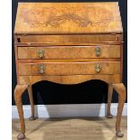 An early 20th century Queen Anne style walnut bureau, fall front enclosing a fitted interior above
