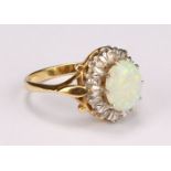 An 18ct gold opal and diamond cluster ring, the central polished oval opal cabochon surrounded by
