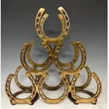 A contemporary brass coloured metal six bottle wine rack, horseshoe design, 40cm high, 41cm wide