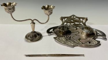 An Art Nouveau lily pad double ink stand with dip pen; a candlestick