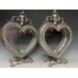 A pair of silver coloured pierced metal heart shaped lanterns, with decoration in relief, 51cm high