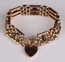 A 9ct rose gold gate link bracelet, set with seven oval cut garnets, love heart clasp and safety