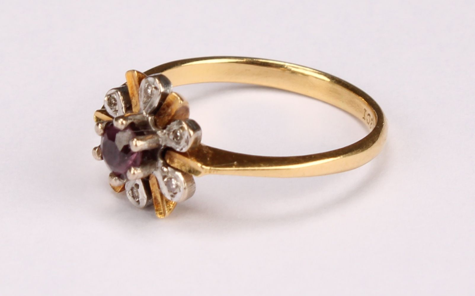 A ruby and diamond flowerhead ring, the central round facet cut stone claw set above six round facet - Image 5 of 5