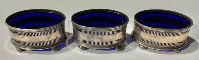 A set of three hallmarked silver salts, with blue glass liners, Birmingham, 1918, 70g