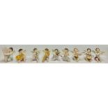 A Dresden porcelain miniature angelic band group, each cherub with a musical instrument, comprising,