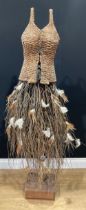 A rustic wicker display mannequin, wicker bodice, hazel twig and feather skirt, on wooden stand,