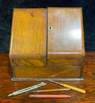 A late Victorian oak table top slope front stationery cabinet, c.1900