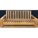 A 20th century beech futon sofa bed, dovetailed armrests, 84cm high (as sofa), 53.5cm high (as bed),