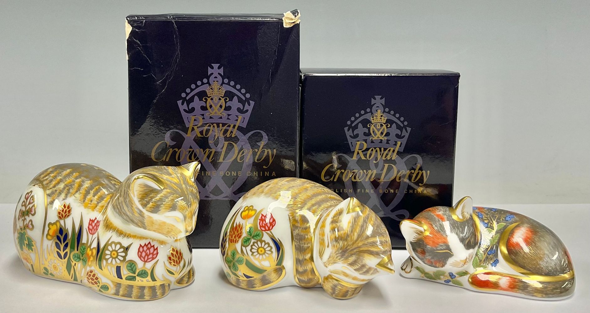 A group of three Royal Crown Derby paperweights, Cottage Garden Cat, 21st anniversary special gold